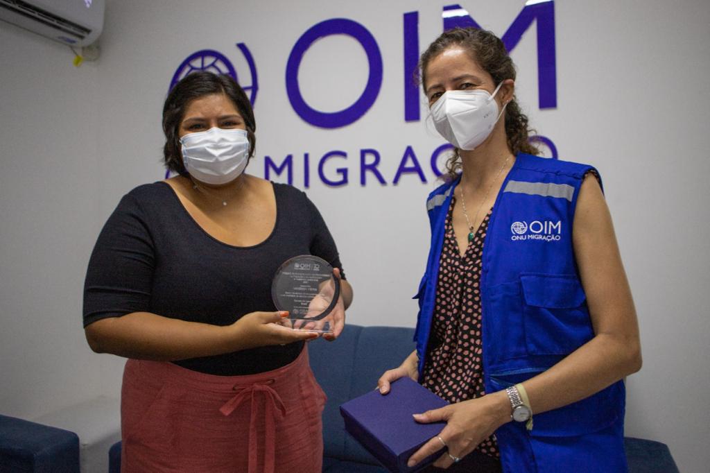A jornalista Vanessa Vieira recebe o prêmio da OIM